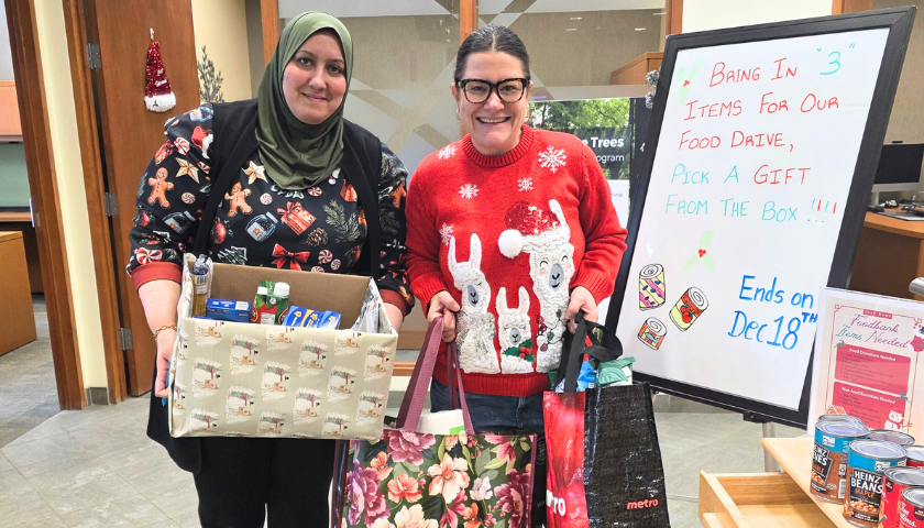 two ladies giving food donations