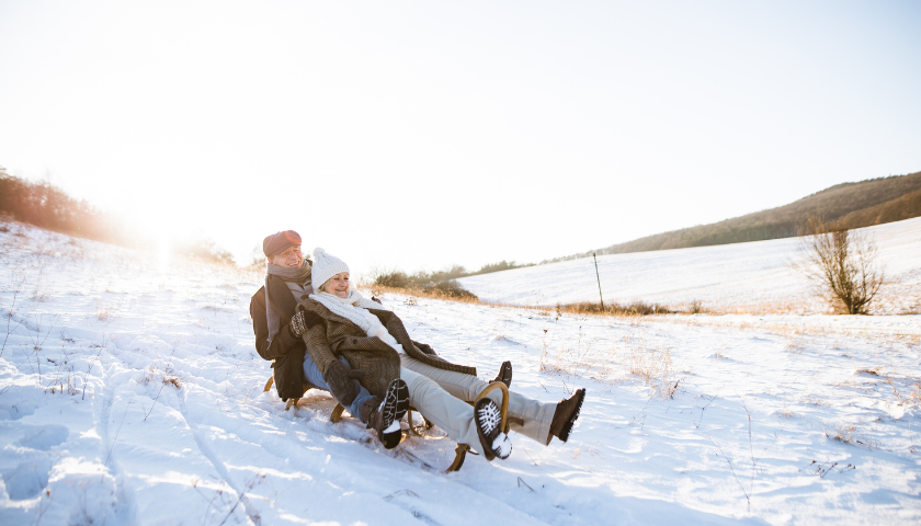 Senior couple tobogganing