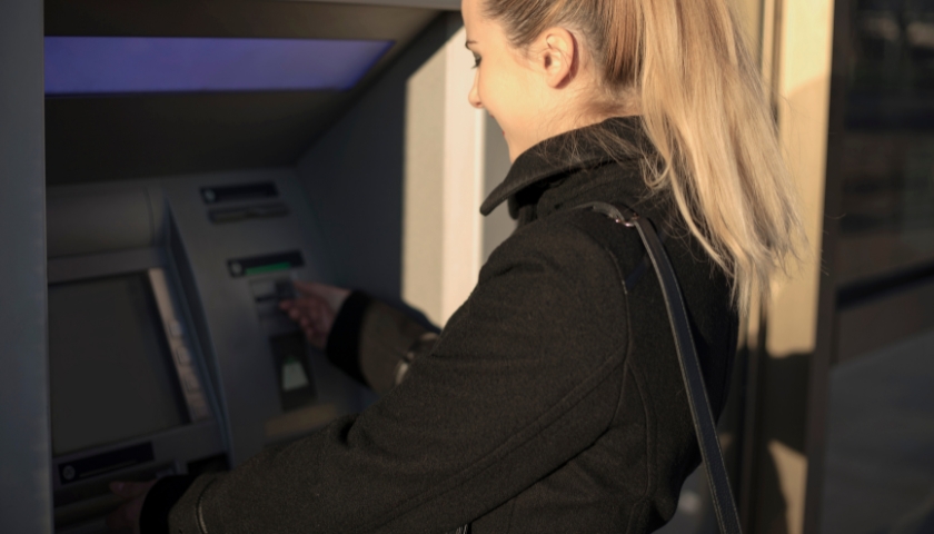 young woman using atm